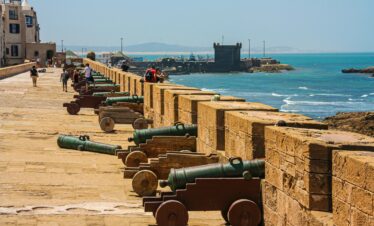 Cannons on a fortress wall facing the sea, capturing historical and coastal scenery.