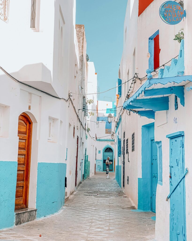 Scenic view of a colorful alley in Asilah, Morocco with traditional architecture.