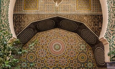 Detailed Moroccan mosaic and arches in a Fes, Morocco courtyard.