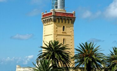 Stunning view of Cape Spartel Lighthouse amidst lush palm trees in Tangier.
