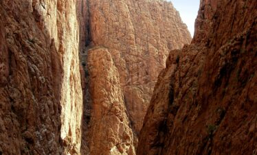 Captivating view of Todra Gorge's towering cliffs and tranquil stream in Tinghir, Morocco.