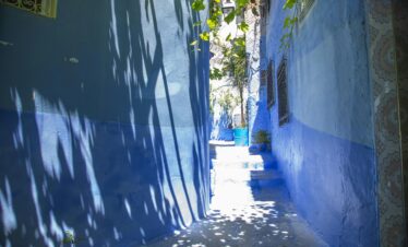 A bright alley in the blue city of Chefchaouen, Morocco, showcasing vibrant architecture.