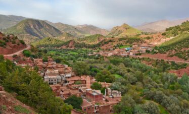 Scenic aerial view of Ait Barka village amidst lush green valleys and rugged mountains.